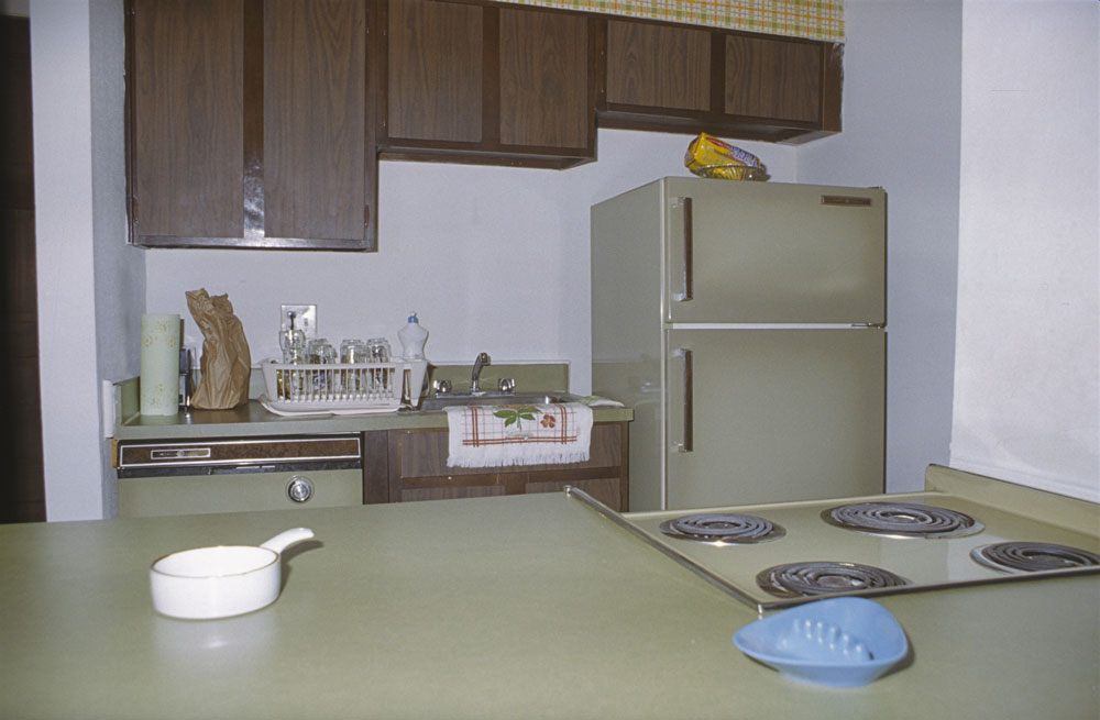 70s realistic kitchen with green appliances and brown cabinets
