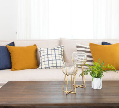 living room with blue and yellow pillows on a white sofa