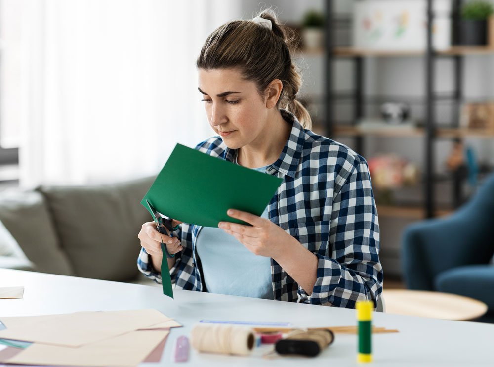 Woman crafting, cutting green paper